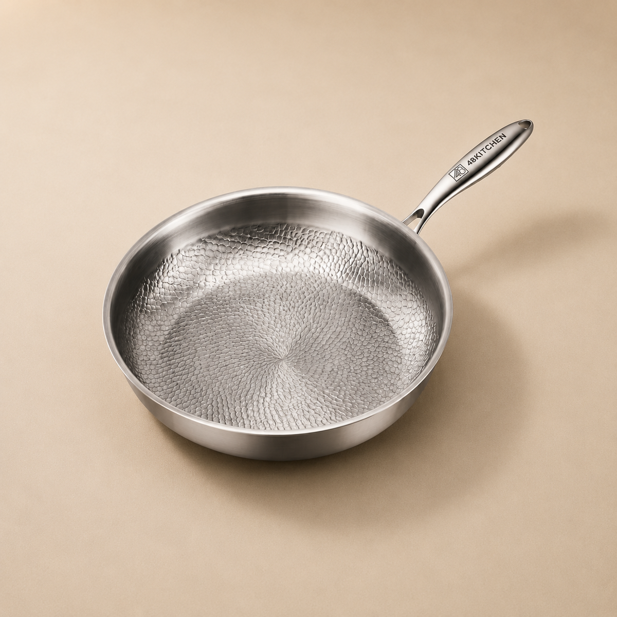 48Kitchen titanium koekenpan 28 cm met gehamerde antiaanbaklaag en metalen handvat op beige achtergrond