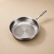48Kitchen titanium koekenpan 28 cm met gehamerde antiaanbaklaag en metalen handvat op beige achtergrond
